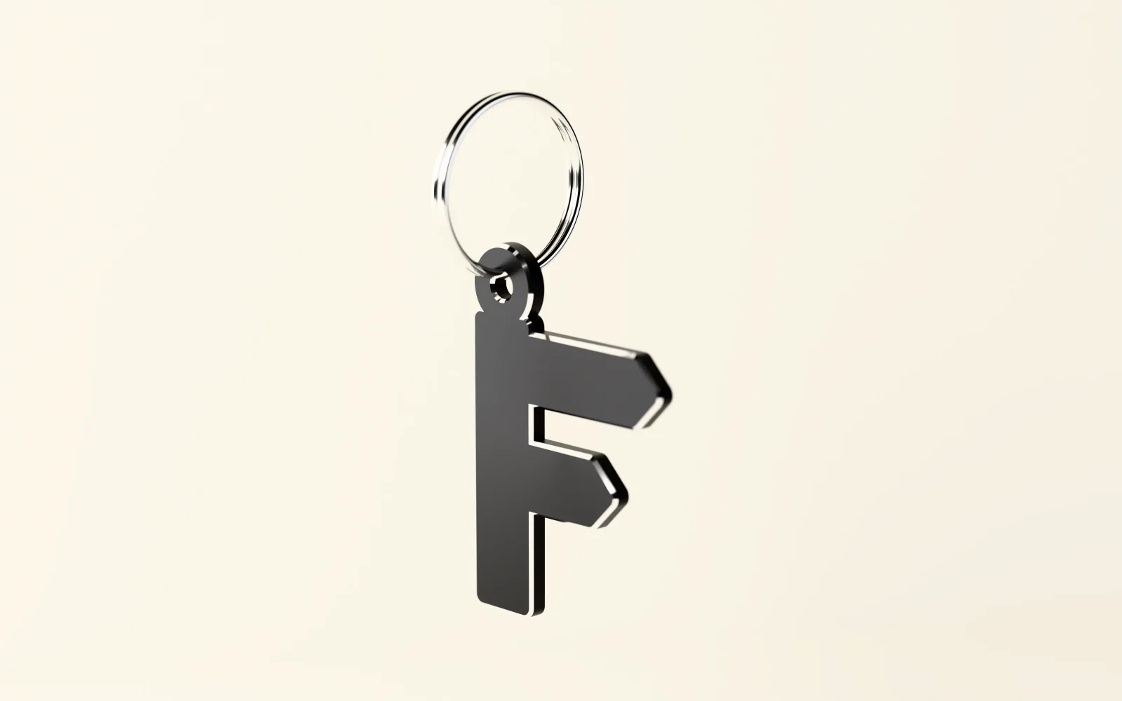 The fingerpost F as a black keyring tag with bright edges, hanging from a steel split ring